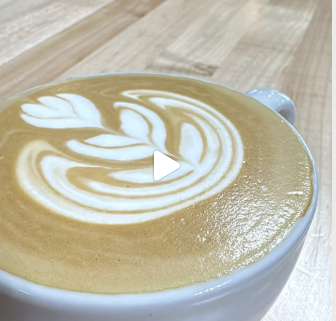 Latte with rosetta art in a blue mug.