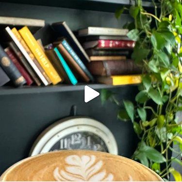 Bookshelf with vintage clock and a latte.